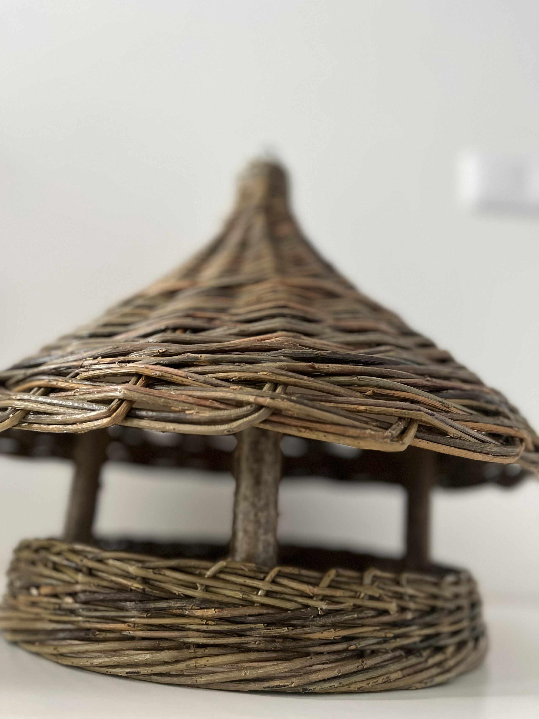 Woven birdhouse made of twigs on a white background